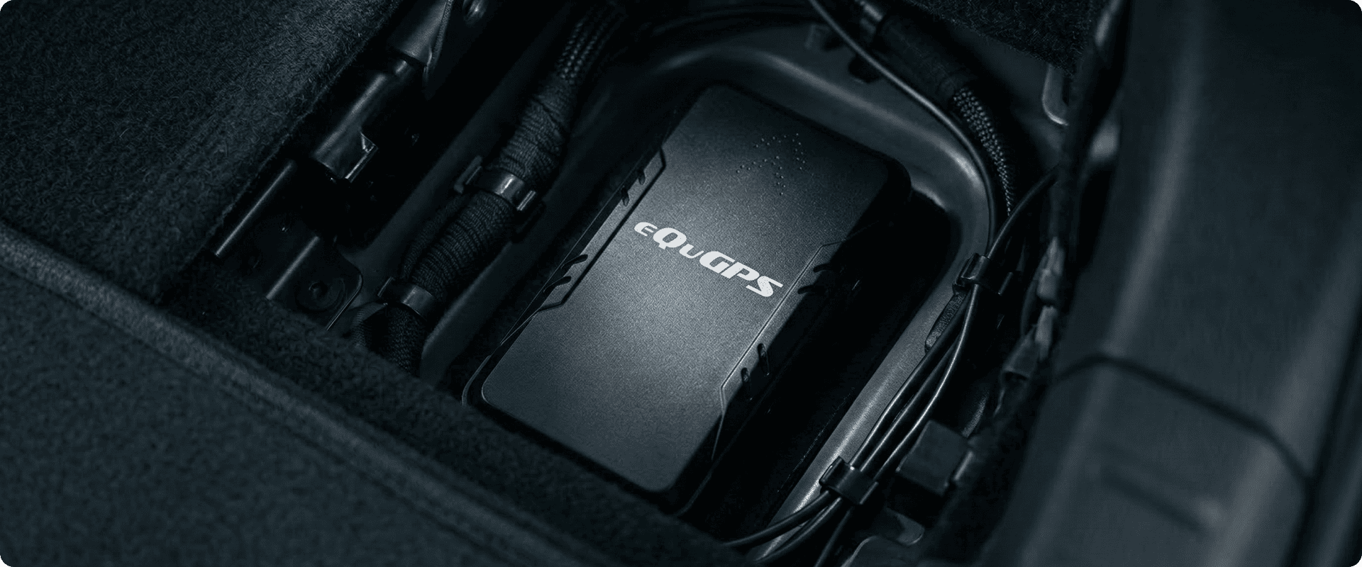 Компактний чорний маяк eQuGPS, приховано встановлений у поглибленні з проводкою транспортного засобу.